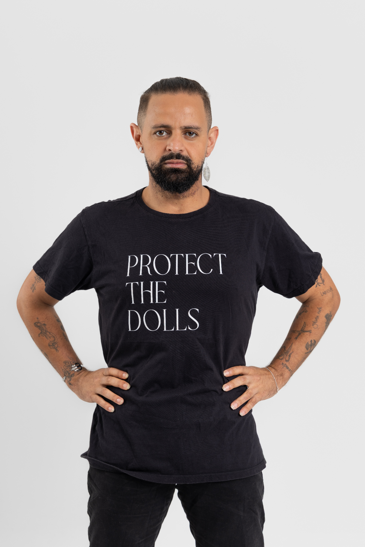 Jayslan Souza em retrato autoral usando camiseta com a frase Protect the Dolls.